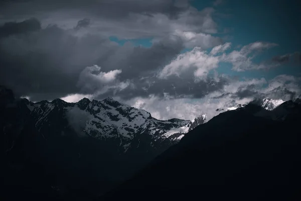 Uma Paisagem Montanhas Rochosas Cobertas Neve Sob Céu Escuro Nublado — Fotografia de Stock