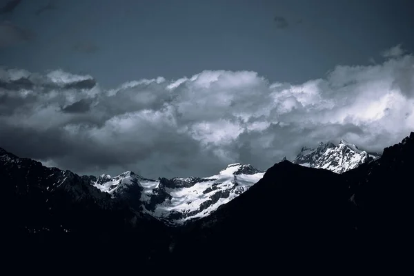 Krajina Skalnatých Hor Pokrytá Sněhem Pod Tmavou Zataženou Oblohou — Stock fotografie