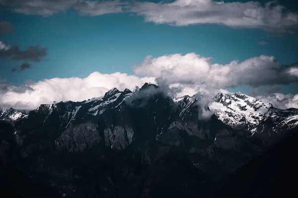 Uma Paisagem Montanhas Rochosas Cobertas Neve Sob Céu Escuro Nublado — Fotografia de Stock