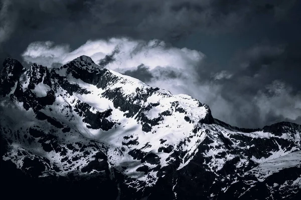 Uma Paisagem Montanhas Rochosas Cobertas Neve Sob Céu Escuro Nublado — Fotografia de Stock