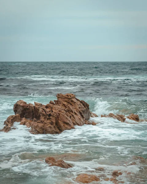 Colpo Verticale Onde Oceaniche Schiumose Che Infrangono Una Spiaggia Rocciosa — Foto Stock