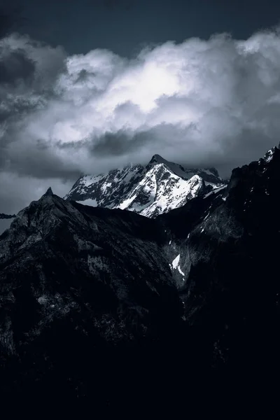 Colpo Verticale Montagne Rocciose Coperte Neve Sotto Cielo Buio Nuvoloso — Foto Stock