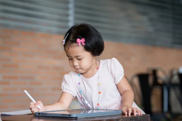 一个亚洲小女孩在公园里用平板电脑 — 图库照片