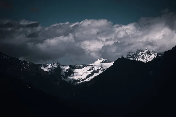 Krajina Skalnatých Hor Pokrytá Sněhem Pod Tmavou Zataženou Oblohou — Stock fotografie