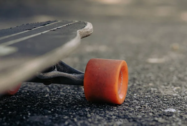 Tiro Foco Seletivo Uma Roda Vermelha Skate Uma Estrada Asfalto — Fotografia de Stock