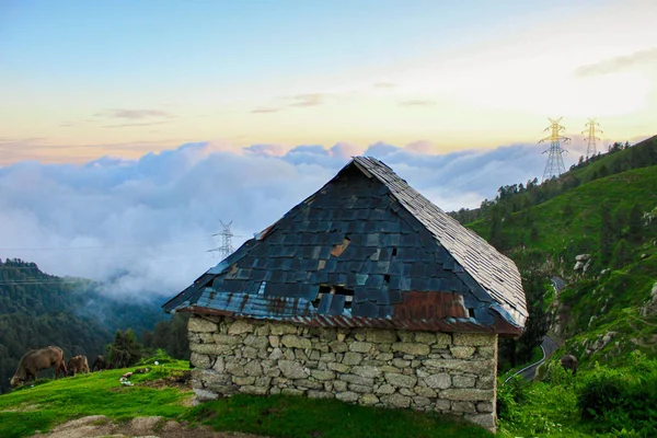 Una Casa Ladrillo Una Montaña Verde Cubierta Nubes — Foto de Stock