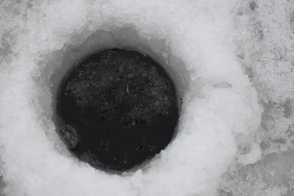 凍った湖で釣りをするための小さな穴 — ストック写真
