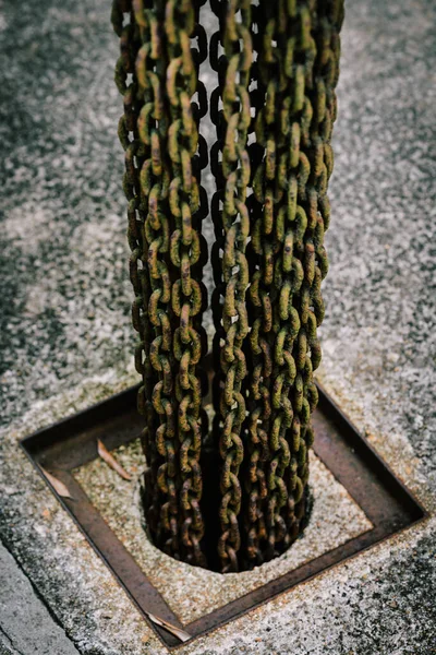 Vertikální Záběr Rezavých Kovových Řetězů Zavěšených Díře — Stock fotografie