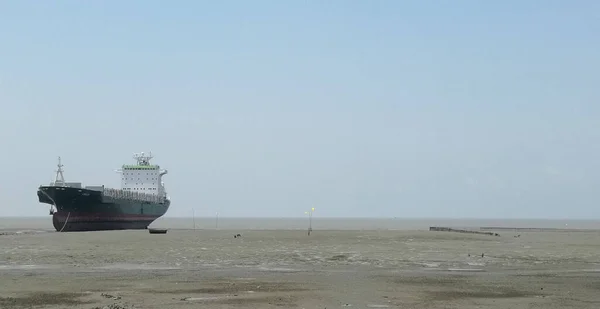 一艘孤零零的大船在清澈的天空下在肮脏的海面上航行 — 图库照片