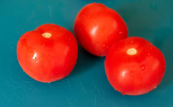 キッチンに水の滴と3つの鮮やかな赤いトマトの閉鎖は スライスされる準備ができて — ストック写真