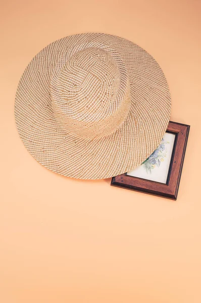 一顶圆圆的草帽和一个画框 隔离在桃色背景上 有空余的文字空间 — 图库照片
