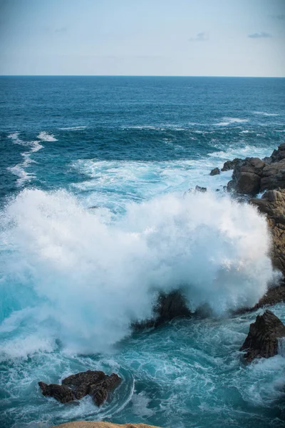 Tiro Vertical Das Ondas Mar Contra Rochas Sob Céu Azul — Fotografia de Stock