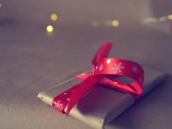 Різдвяний Подарунок Загорнутий Червоною Стрічкою Боке Запалює Фон — стокове фото