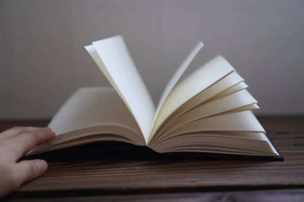 Una Mano Che Tiene Aperto Libro Bianco Una Superficie Legno — Foto Stock