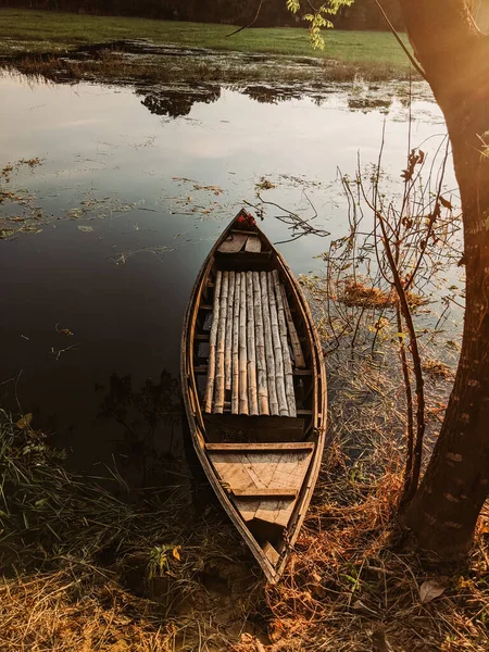 日没時に湖畔の古い木のボート — ストック写真