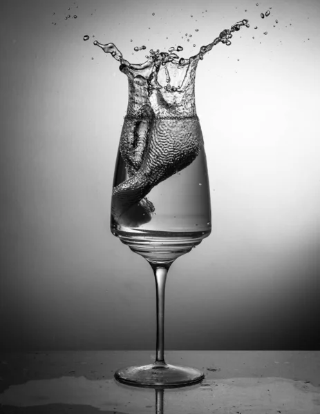 Colpo Verticale Scala Grigi Bicchiere Vino Con Spruzzi Acqua — Foto Stock