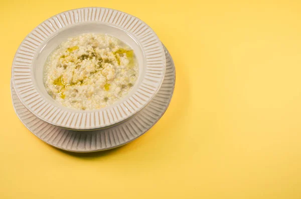 黄色の背景にトウモロコシと溶かしたバターを溶かしたおいしいお粥のプレート — ストック写真