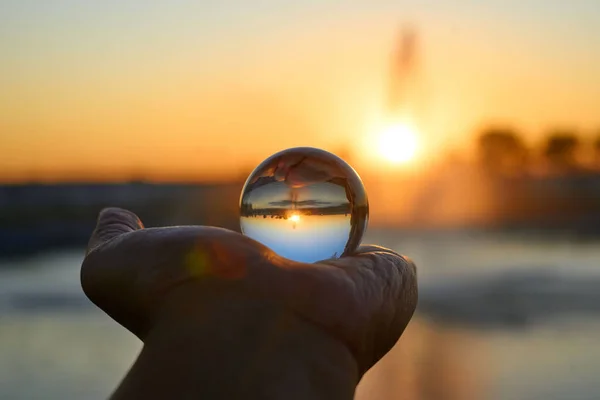 Una Hermosa Puesta Sol Tergiversación Abstracta Una Bola Vidrio Mano — Foto de Stock