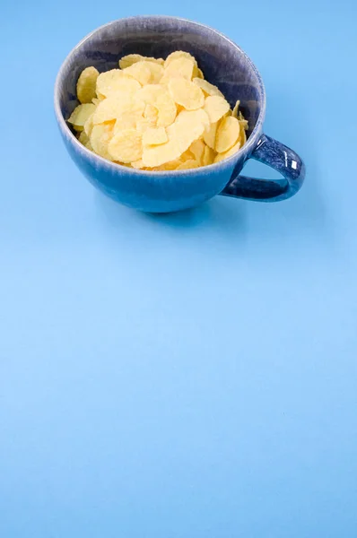 Een Verticaal Van Cornflakes Een Beker Geïsoleerd Blauwe Achtergrond — Stockfoto