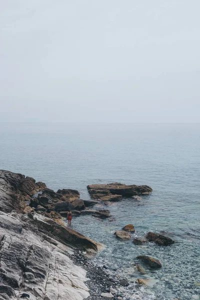 Μια Κάθετη Βολή Βράχων Δίπλα Στη Θάλασσα Ομιχλώδες Φόντο — Φωτογραφία Αρχείου