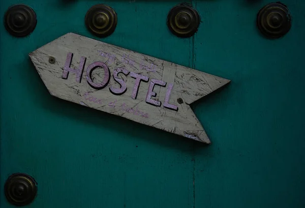 金属ラウンド要素と壁の上のホステルへの木製の方向標識 — ストック写真