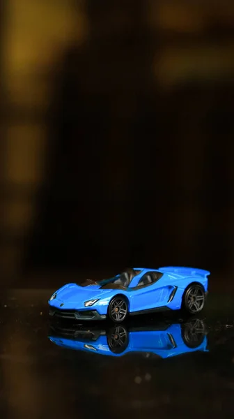 Eine Vertikale Aufnahme Eines Blauen Autos Auf Dunklem Hintergrund — Stockfoto