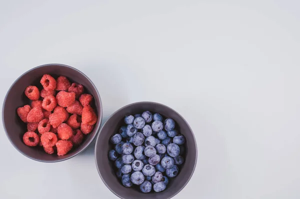 Die Schalen Mit Frischen Blaubeeren Und Himbeeren Isoliert Auf Weißem — Stockfoto