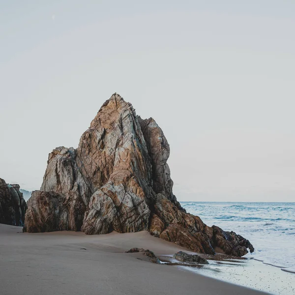 一个有着岩石峭壁的田园诗般的沙质海岸的垂直镜头 — 图库照片