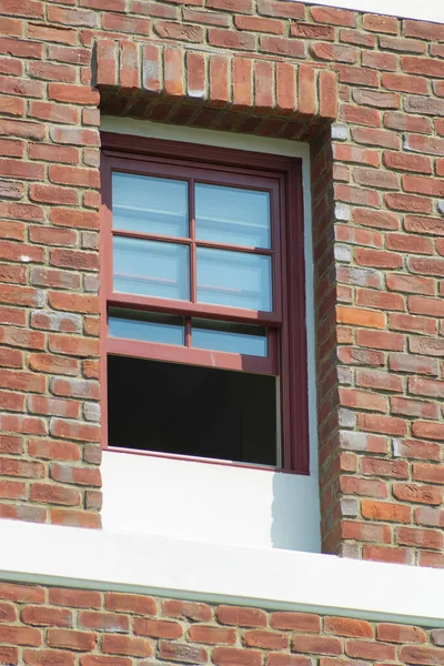 ガラス窓が開いている古いレンガ壁の建物の垂直ショット — ストック写真