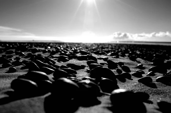 透过散落在海岸上的石头 可以看到阳光灿烂的景象 — 图库照片