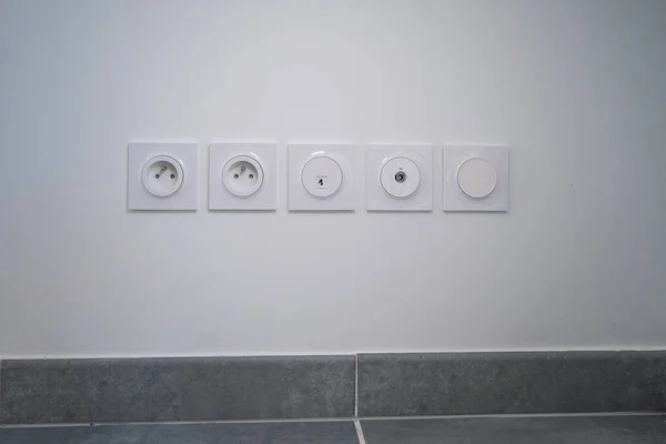Beyaz Bir Duvarda Farklı Güç Prizleri Olan Bir Sıranın Yakın — Stok fotoğraf