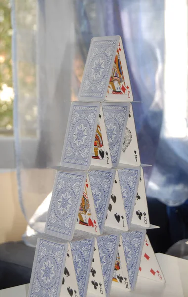 Eine Vertikale Nahaufnahme Eines Kartenhauses Auf Dem Tisch Innenraum — Stockfoto