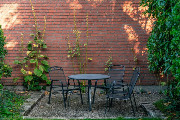 Uma Mesa Metal Preto Com Cadeiras Livre Jardim Frente Parede — Fotografia de Stock
