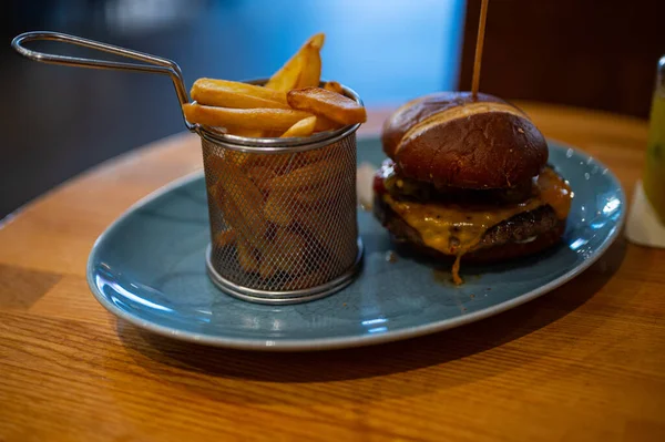 Zbliżenie Cheeseburgera Frytek Serwowane Niebieskim Talerzu — Zdjęcie stockowe