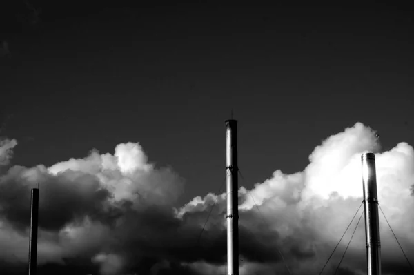 Kabarık Bulutların Arkasındaki Fabrikadaki Endüstriyel Boruların Gri Ölçekli Görüntüsü — Stok fotoğraf
