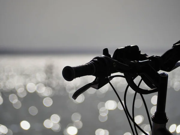 Close Black Bike Handlebar Shining Bokeh Blurred Water Background Sunny — Stock Photo, Image