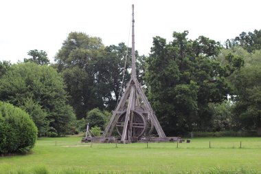 The trebuchet of the Warwick Castle surrounded by greenery in the daylight in the UK clipart