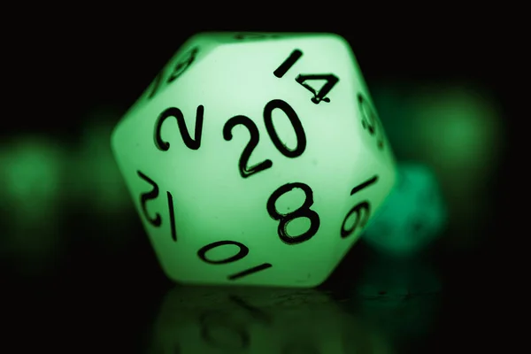 Closeup Green Glowing Icosahedral Dice Table Dark Blurry Backgro — Stock Photo, Image