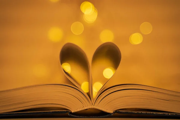 Крупный План Открытой Книги Сложенными Страницами Образующими Сердце Золотом Светящемся — стоковое фото