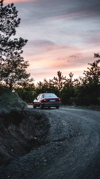 日没時に曲がりくねった道を走る車の垂直ショット — ストック写真