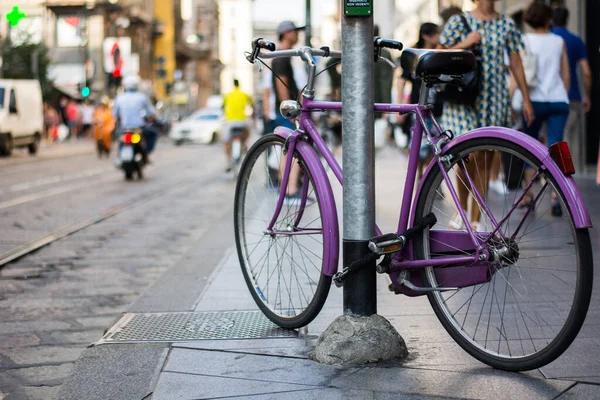 停在街上金属杆旁边的一辆紫色自行车的特写镜头 — 图库照片