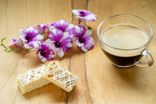 Eine Nahaufnahme Von Gebäck Lila Blumen Und Einer Tasse Kaffee — Stockfoto