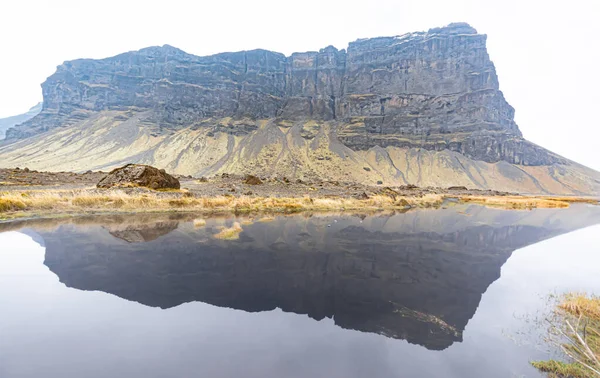 水面に岩山が映り込む穏やかな湖の景色 — ストック写真