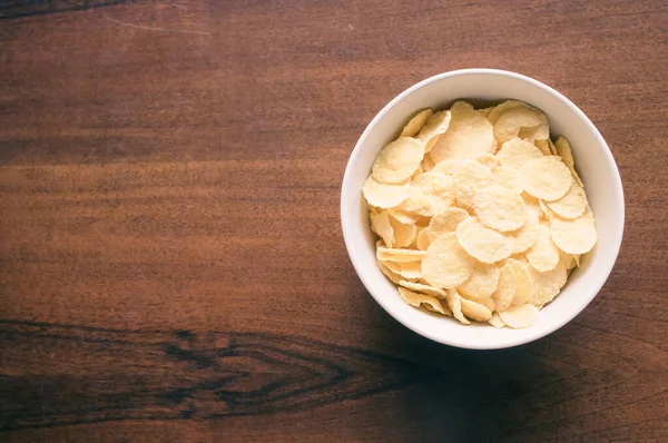 Een Kom Cornflakes Geïsoleerd Een Houten Tafel Met Vrije Ruimte — Stockfoto