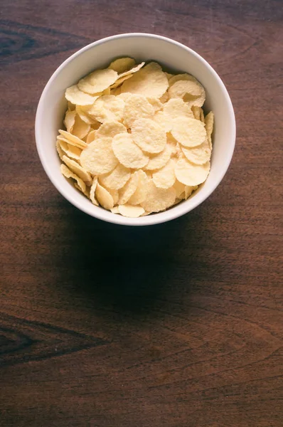Een Kom Cornflakes Geïsoleerd Een Houten Tafel Met Vrije Ruimte — Stockfoto