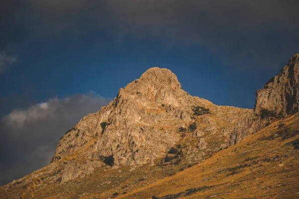 Una Montagna Rocciosa Con Erba Sopra Sotto Cielo Blu — Foto Stock
