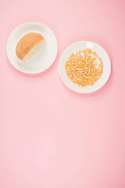 ピンクの背景にトウモロコシとパンの半分の垂直ショット — ストック写真