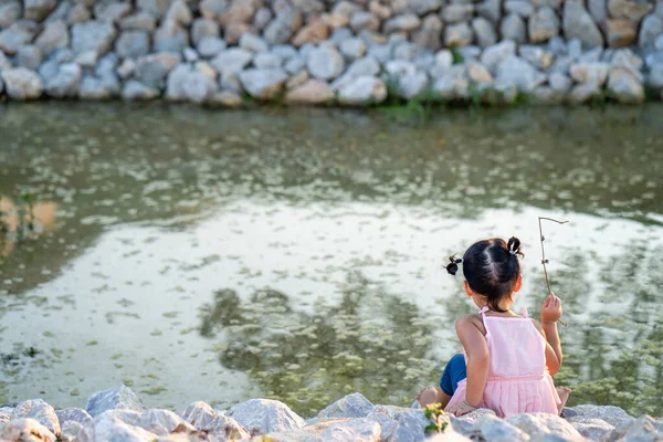 Вид Сзади Симпатичной Маленькой Тайской Девочки Играющей Скалистом Берегу Пруда — стоковое фото