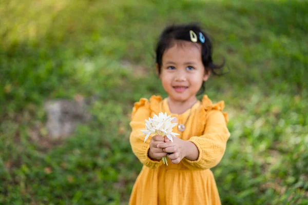 Uma Menina Tailandesa Pequena Bonito Vestido Amarelo Segurando Flores Brancas — Fotografia de Stock