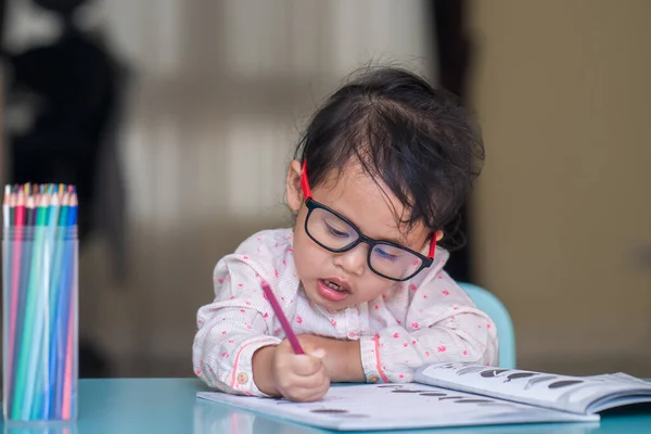 一个可爱的小女孩从泰国戴眼镜在室内学习 — 图库照片